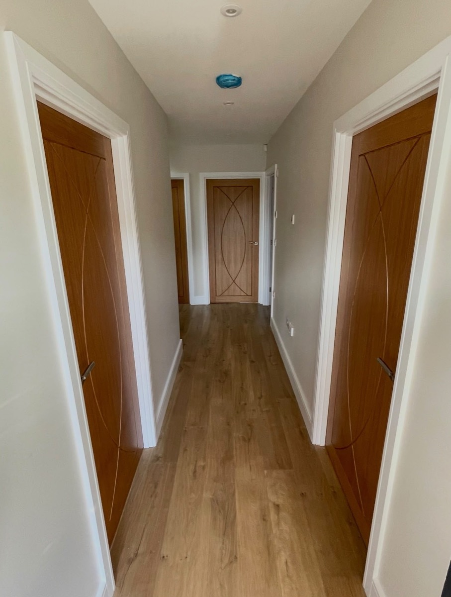 Interior hallway with wood effect flooring and feature doors