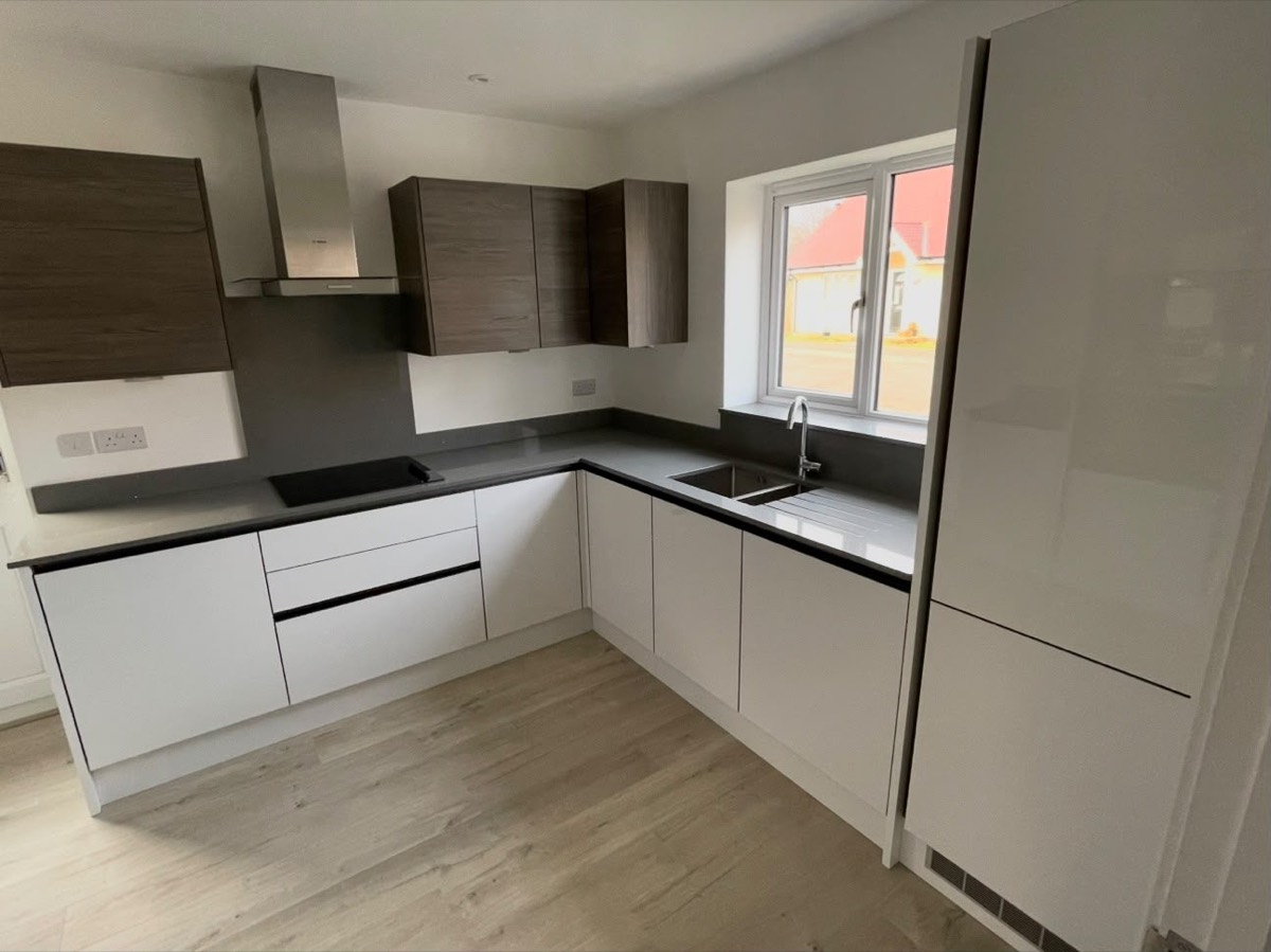 Contemporary kitchen with white base units and wood effect wall cabinets