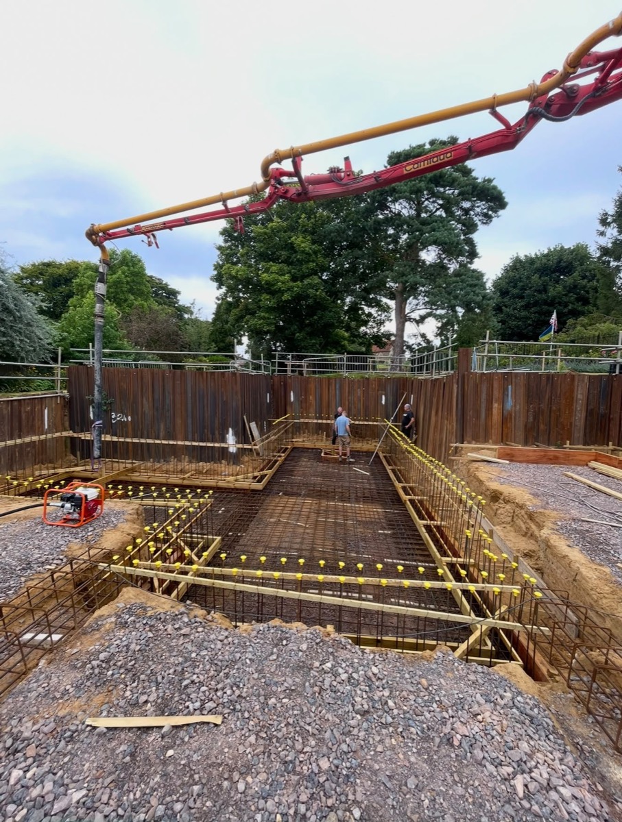 Basement excavation with rebar cages and concrete pump boom