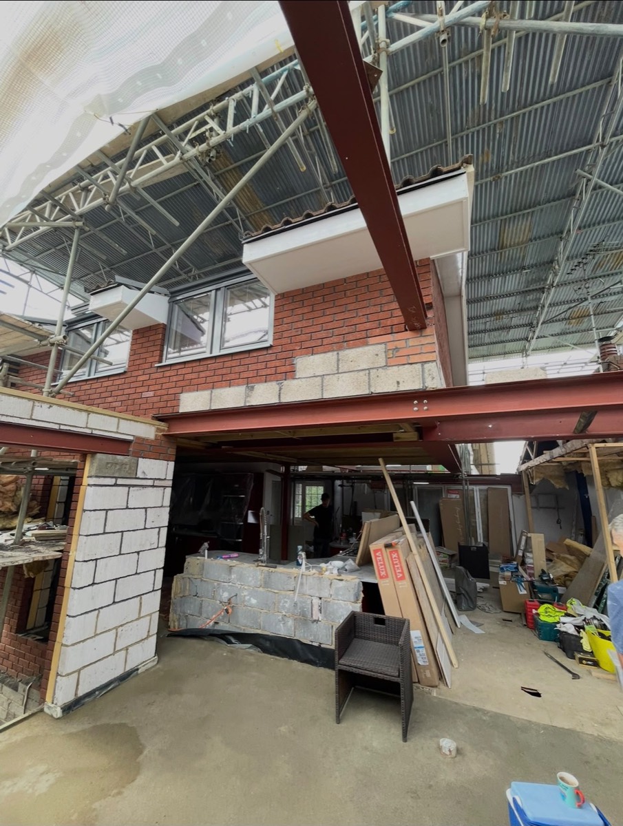 Structural steel and brickwork under scaffolding with temporary roof